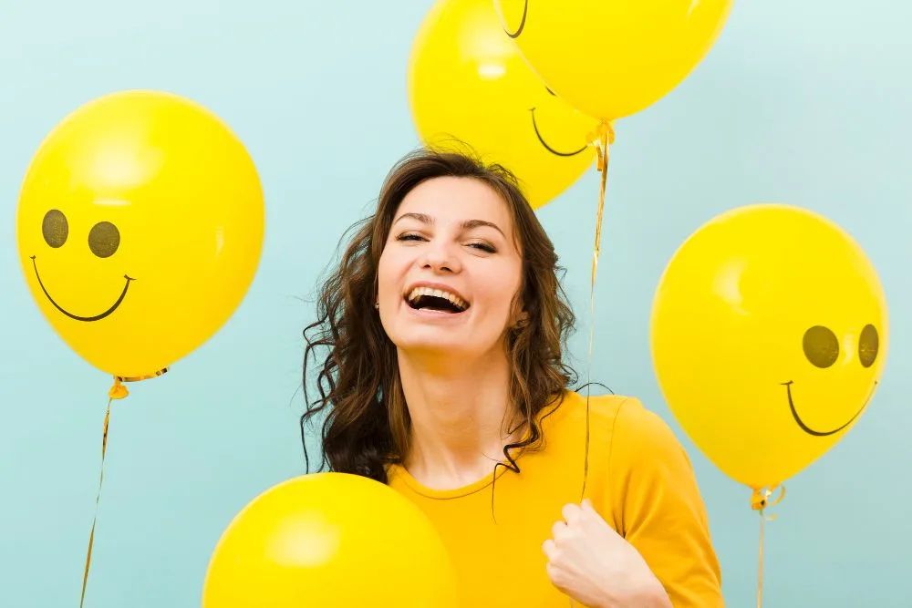 "Mujer sonriente", "que es psicología positiva", globos con carita feliz