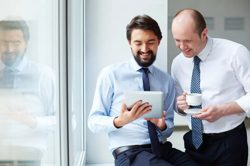 Dos compañeros de oficina revisando proyecto en tablet