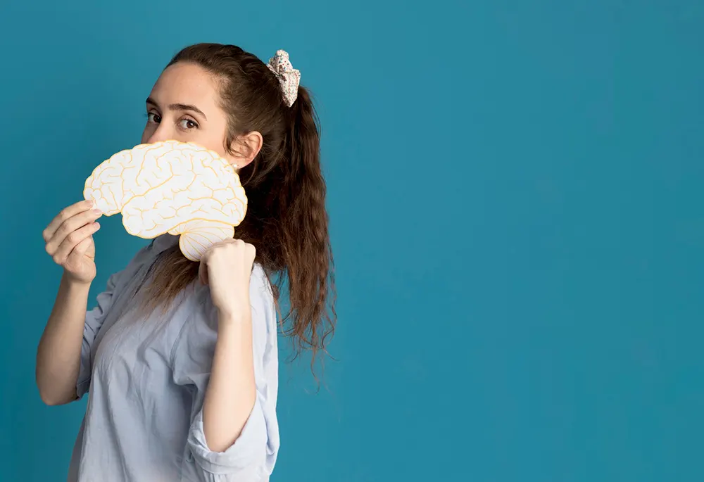 Mujer sosteniendo el dibujo de un cerebro expresando inteligencia emocional en la empresa