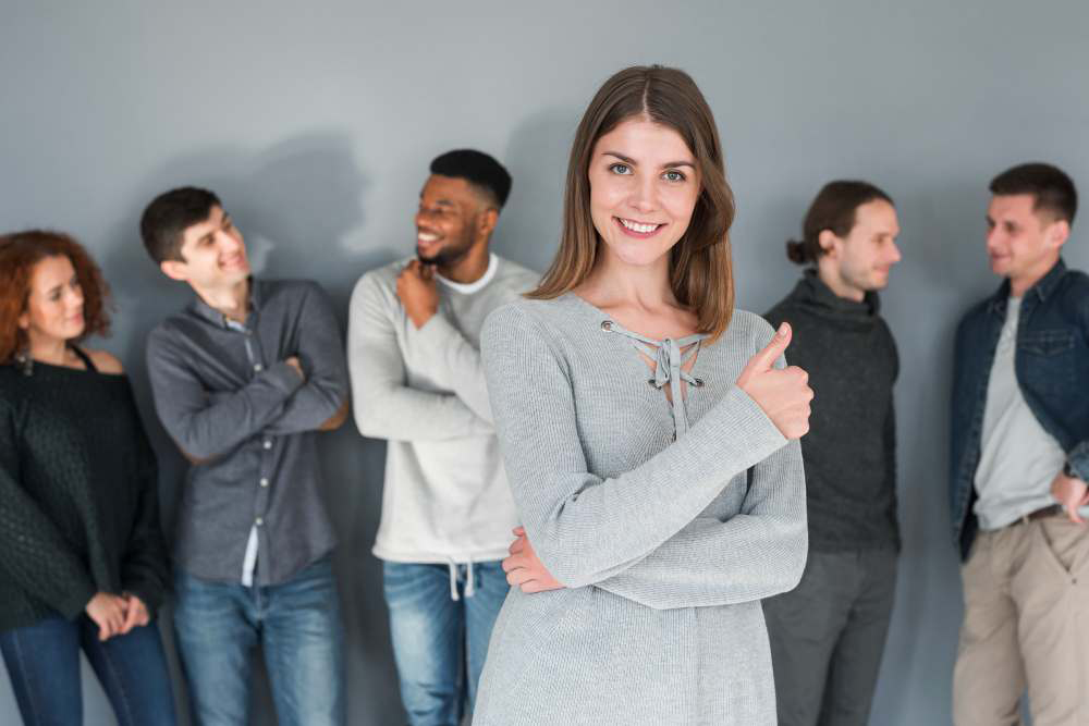 Mujer sonriente confidente reunida con otras personas