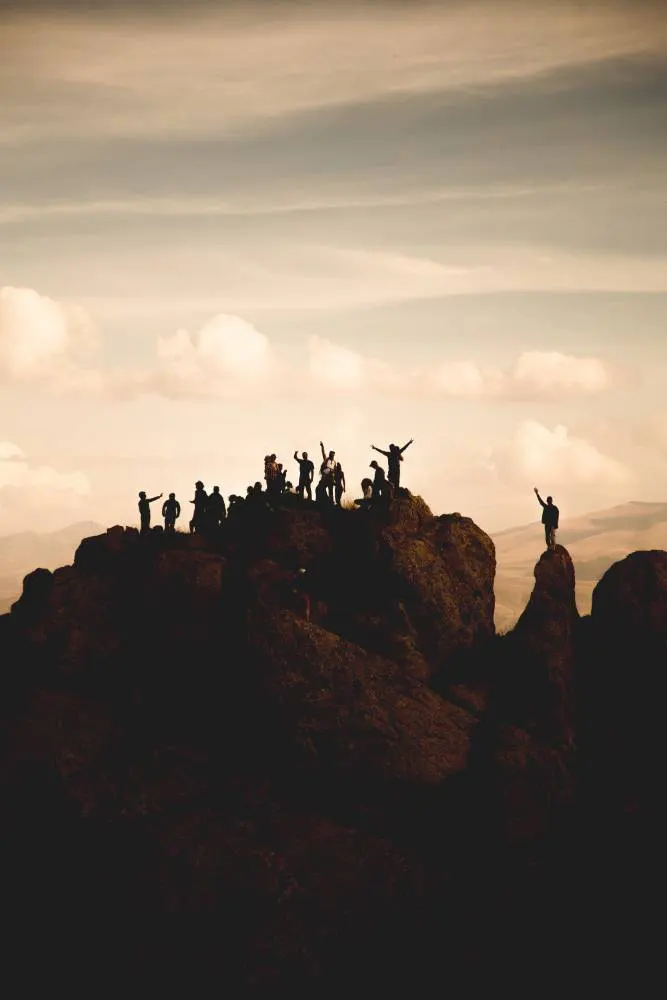 Grupo de personas en la cima de una montana celebrando la meta, coaching en liderazgo