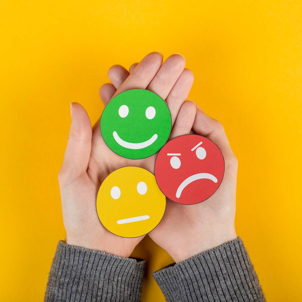 Manos sosteniendo emoticones